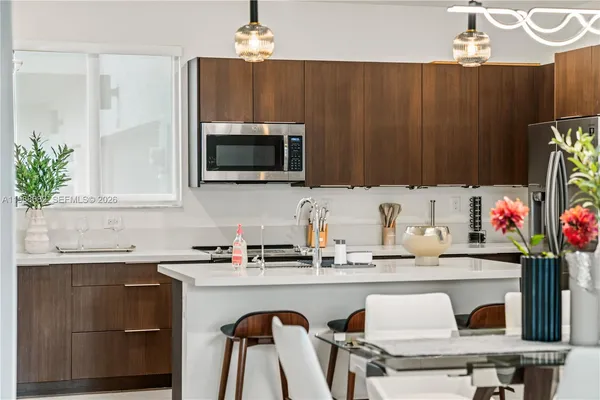 a kitchen with kitchen island granite countertop a sink white cabinets and stainless steel appliances