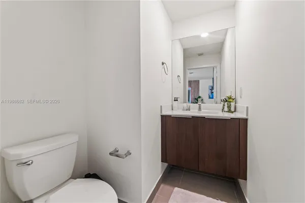 a bathroom with a toilet a sink and mirror