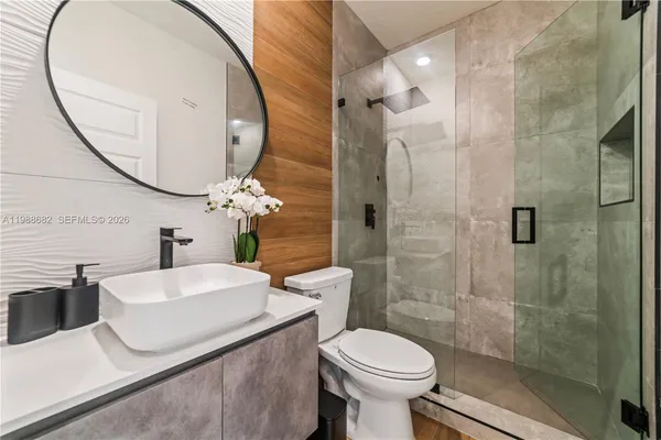 a bathroom with a sink a toilet and a mirror