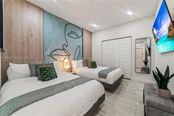 a bedroom with bed and a potted plant