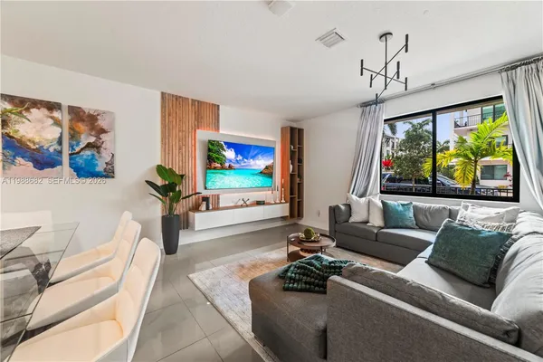 a living room with furniture a window and a flat screen tv