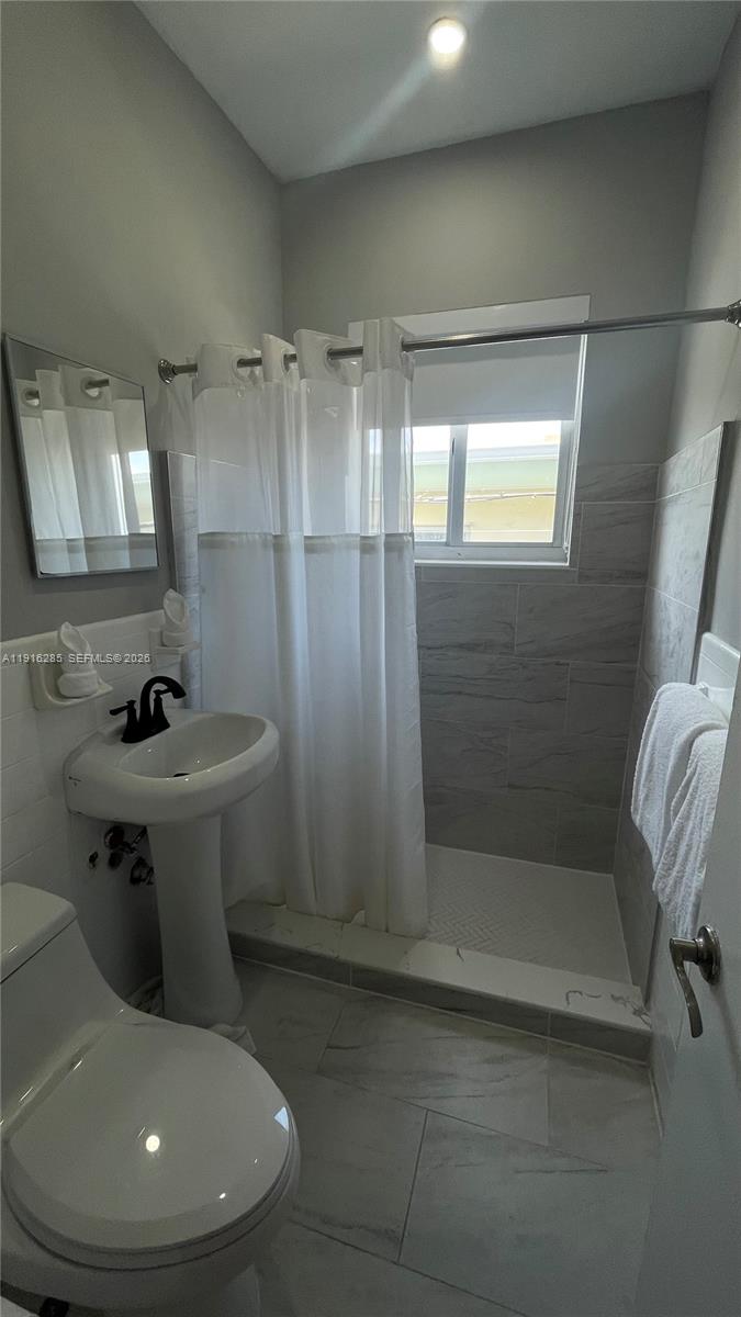 8100 Harding Avenue, Unit 508 Miami Beach, FL 33141 - Photo 15 of 20 a bathroom with a sink toilet and shower