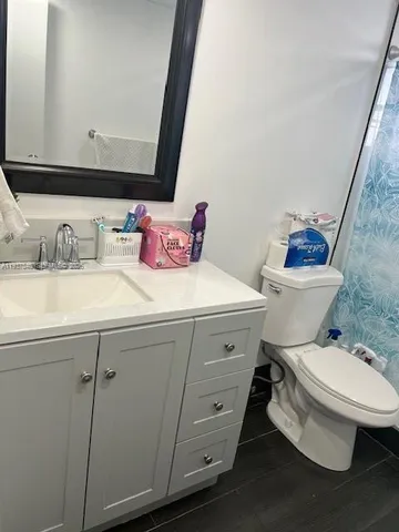 a bathroom with a sink a toilet and a mirror
