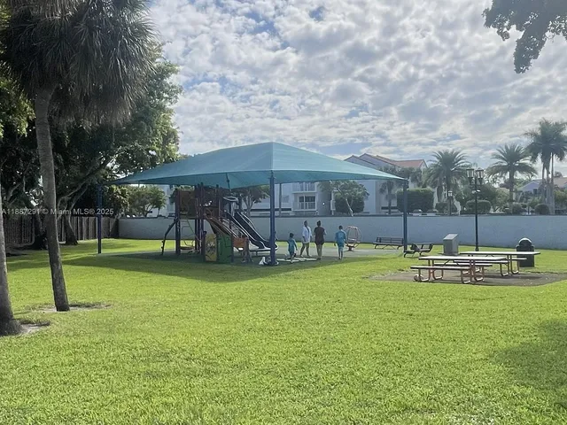a view of a swimming pool with a lawn chairs and palm tree