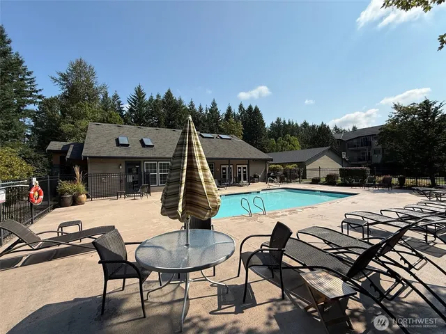 a view of a house with pool and sitting area