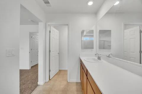 a spacious bathroom with a double vanity sink a mirror and a shower