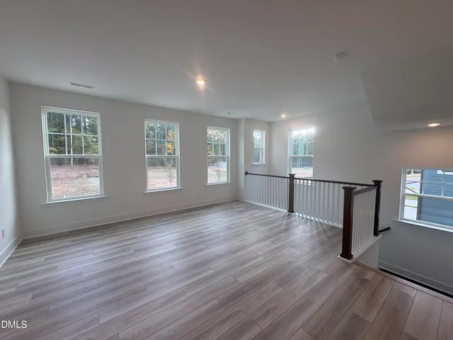 a room with a bed and a dresser with wooden floor