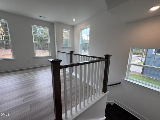 a large kitchen with stainless steel appliances kitchen island a large counter top and a wooden floors