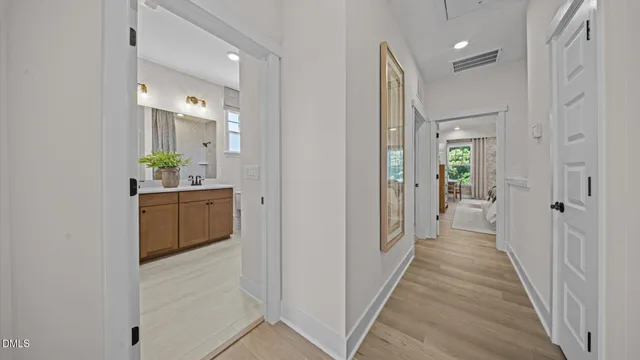 a bathroom with a sink a mirror a toilet and a window