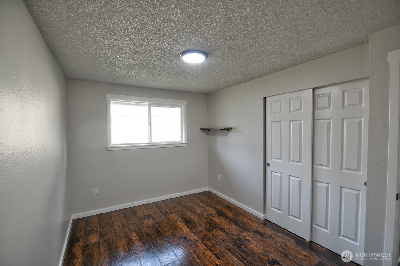 19140 Rosemary Street Southwest Rochester, WA 98579 - Photo 16 of 26 an empty room with wooden floor and windows