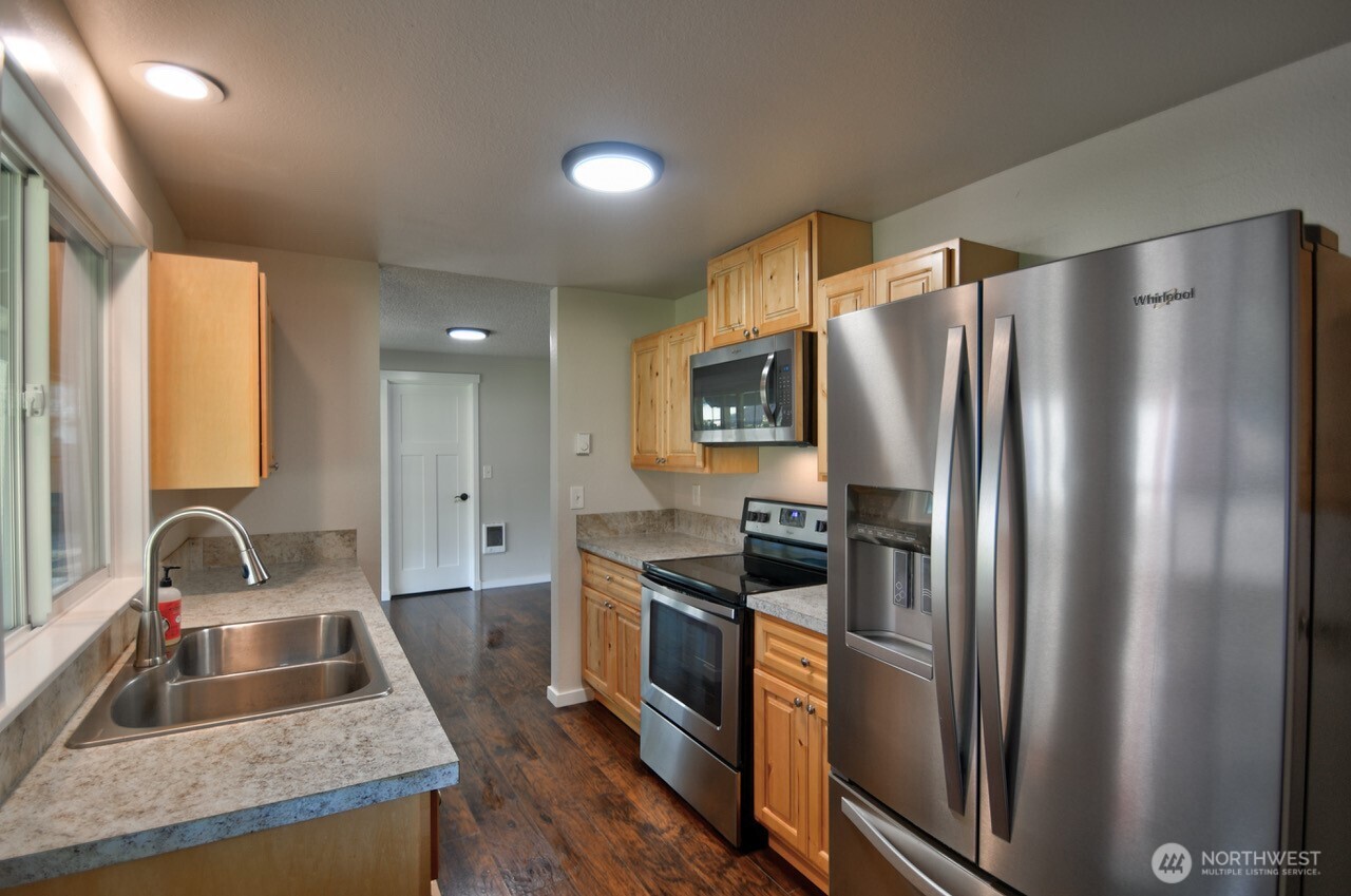 19140 Rosemary Street Southwest Rochester, WA 98579 - Photo 3 of 26 a kitchen with granite countertop a refrigerator and a sink
