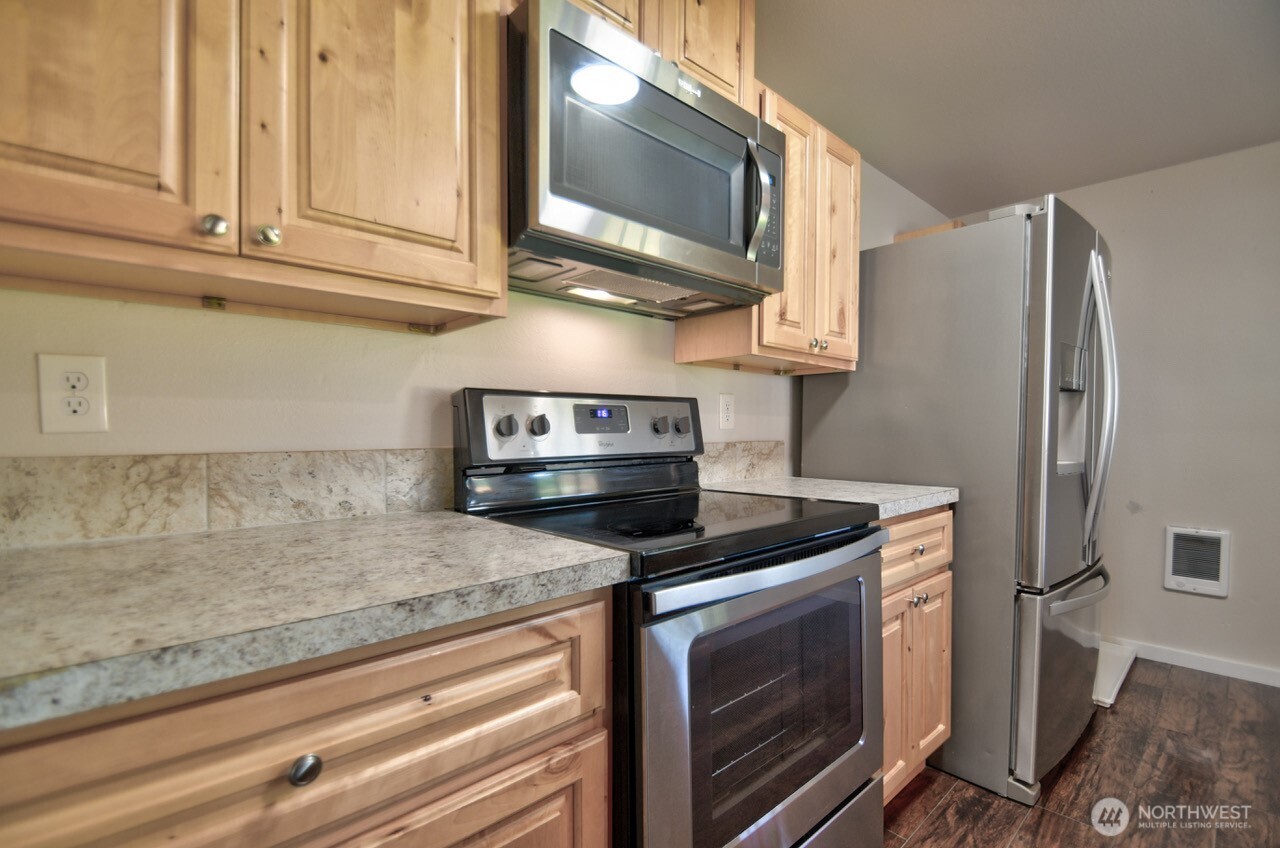19140 Rosemary Street Southwest Rochester, WA 98579 - Photo 5 of 26 a kitchen with stainless steel appliances granite countertop a sink a stove and a refrigerator