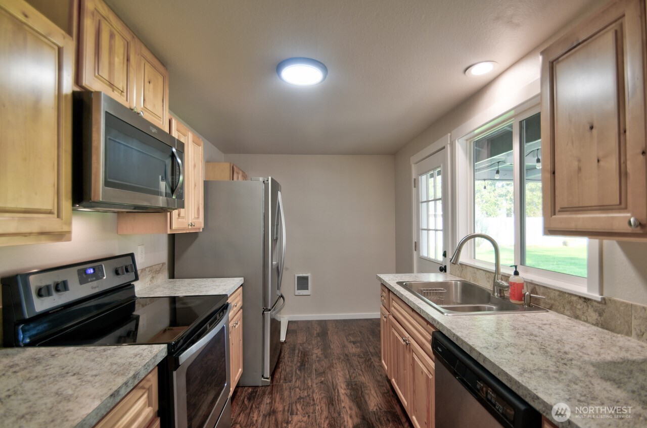 19140 Rosemary Street Southwest Rochester, WA 98579 - Photo 6 of 26 a kitchen with granite countertop a sink a stove and refrigerator