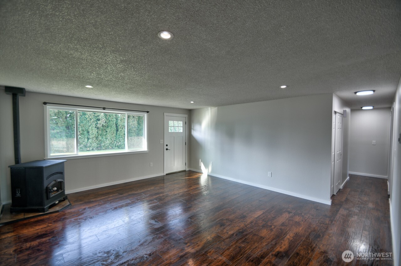 19140 Rosemary Street Southwest Rochester, WA 98579 - Photo 8 of 26 an empty room with wooden floor and windows