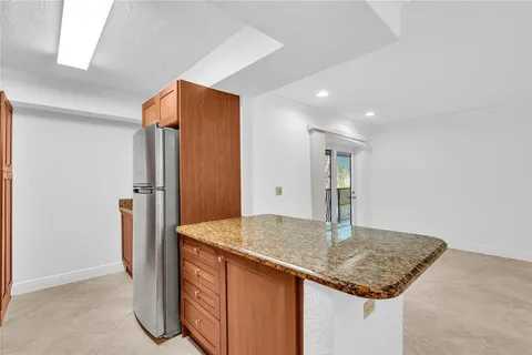 a kitchen with stainless steel appliances granite countertop a refrigerator and a sink