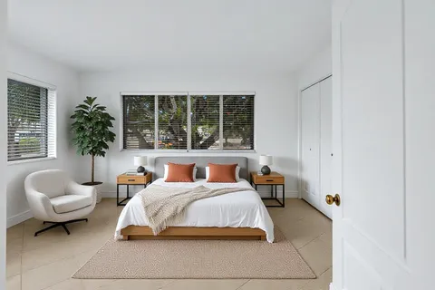 a bedroom with furniture and a large window