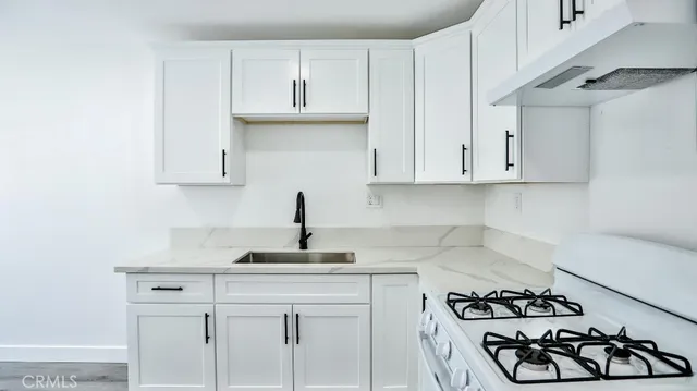 a kitchen with stainless steel appliances granite countertop a sink stove and cabinets
