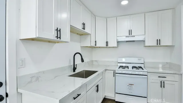 a kitchen with white cabinets stainless steel appliances and sink
