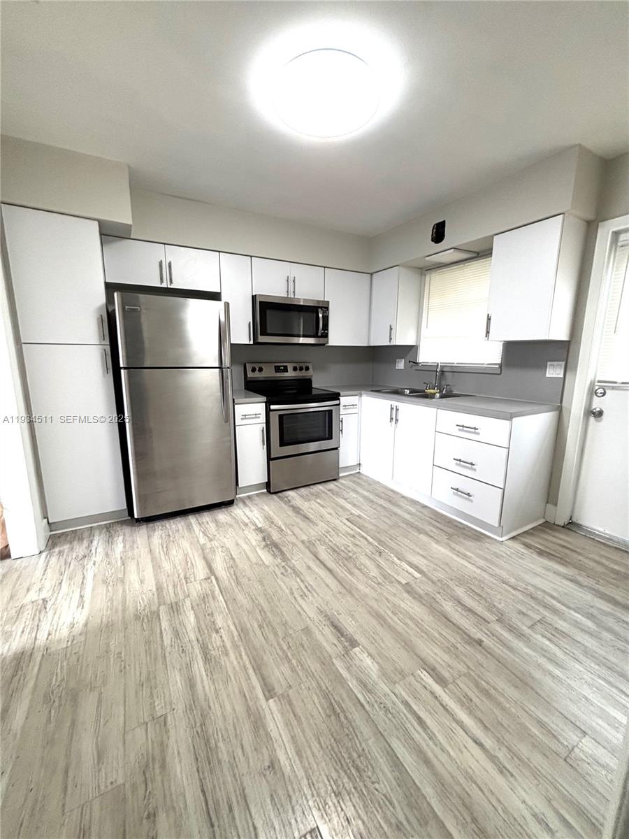 a kitchen with granite countertop a refrigerator stove a sink and dishwasher