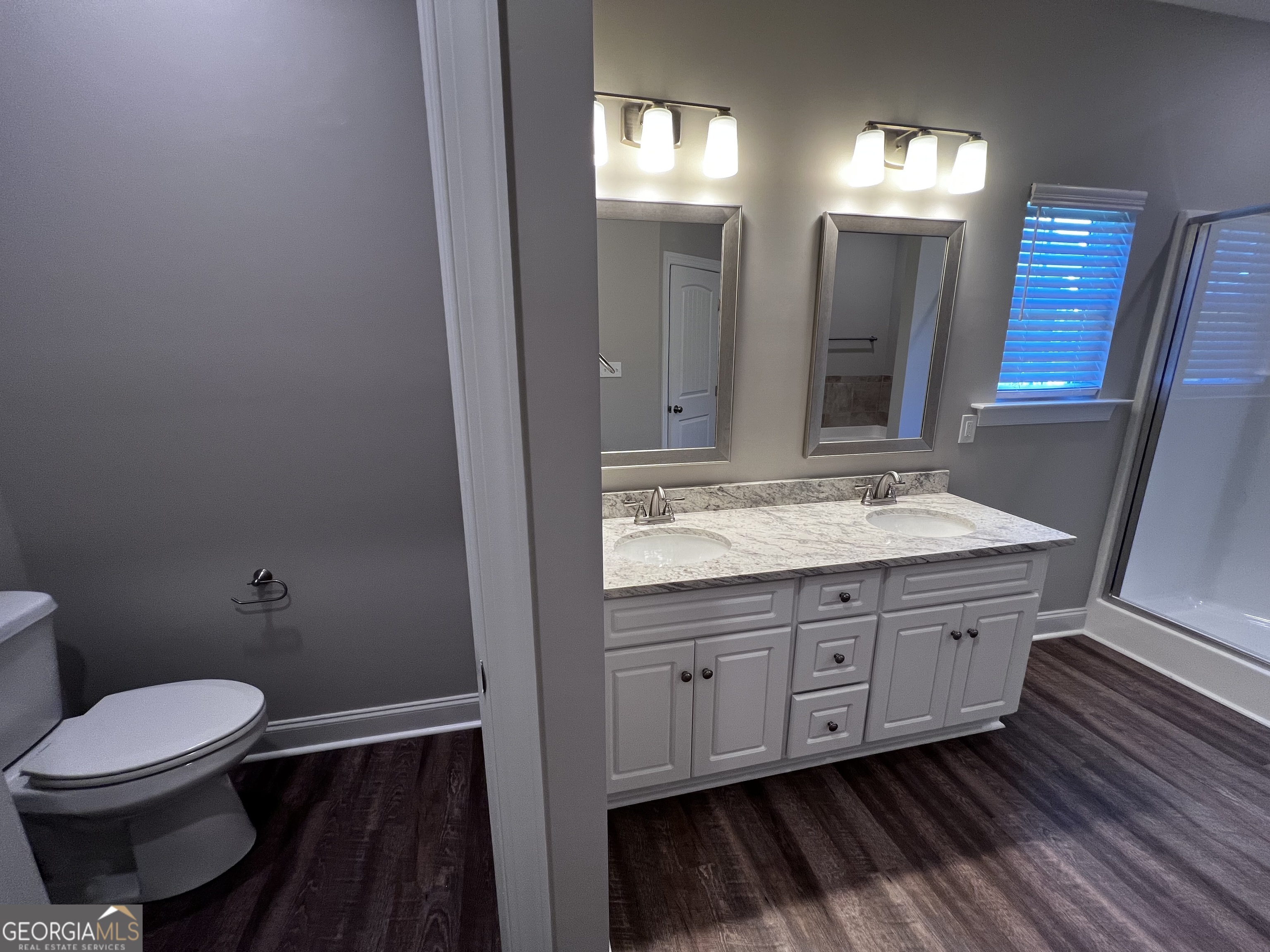 1045 Berkley Court Thomson, GA 30824 - Photo 17 of 32 a bathroom with a granite countertop toilet a sink and a mirror