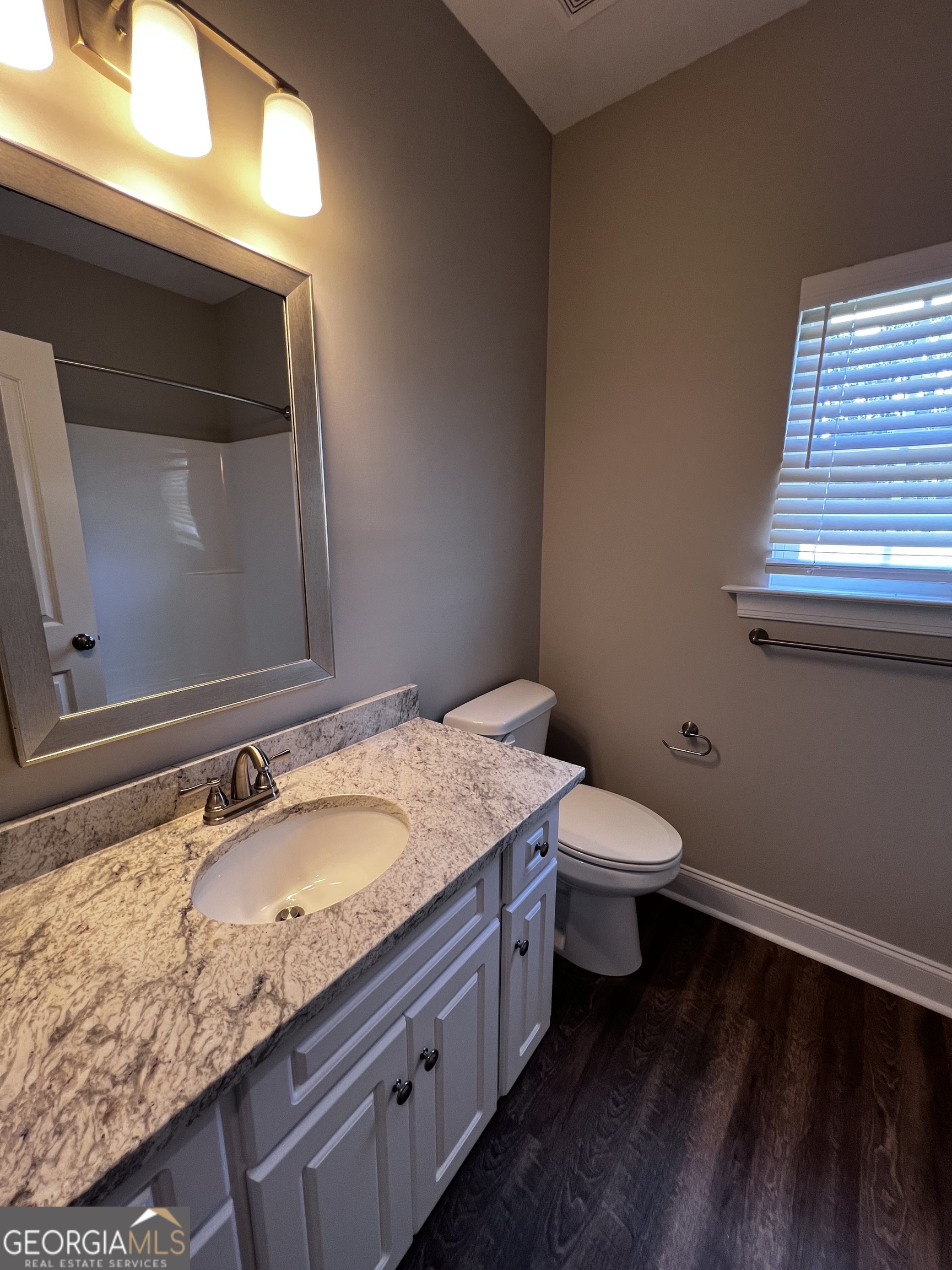 1045 Berkley Court Thomson, GA 30824 - Photo 23 of 32 a bathroom with a granite countertop toilet sink and mirror