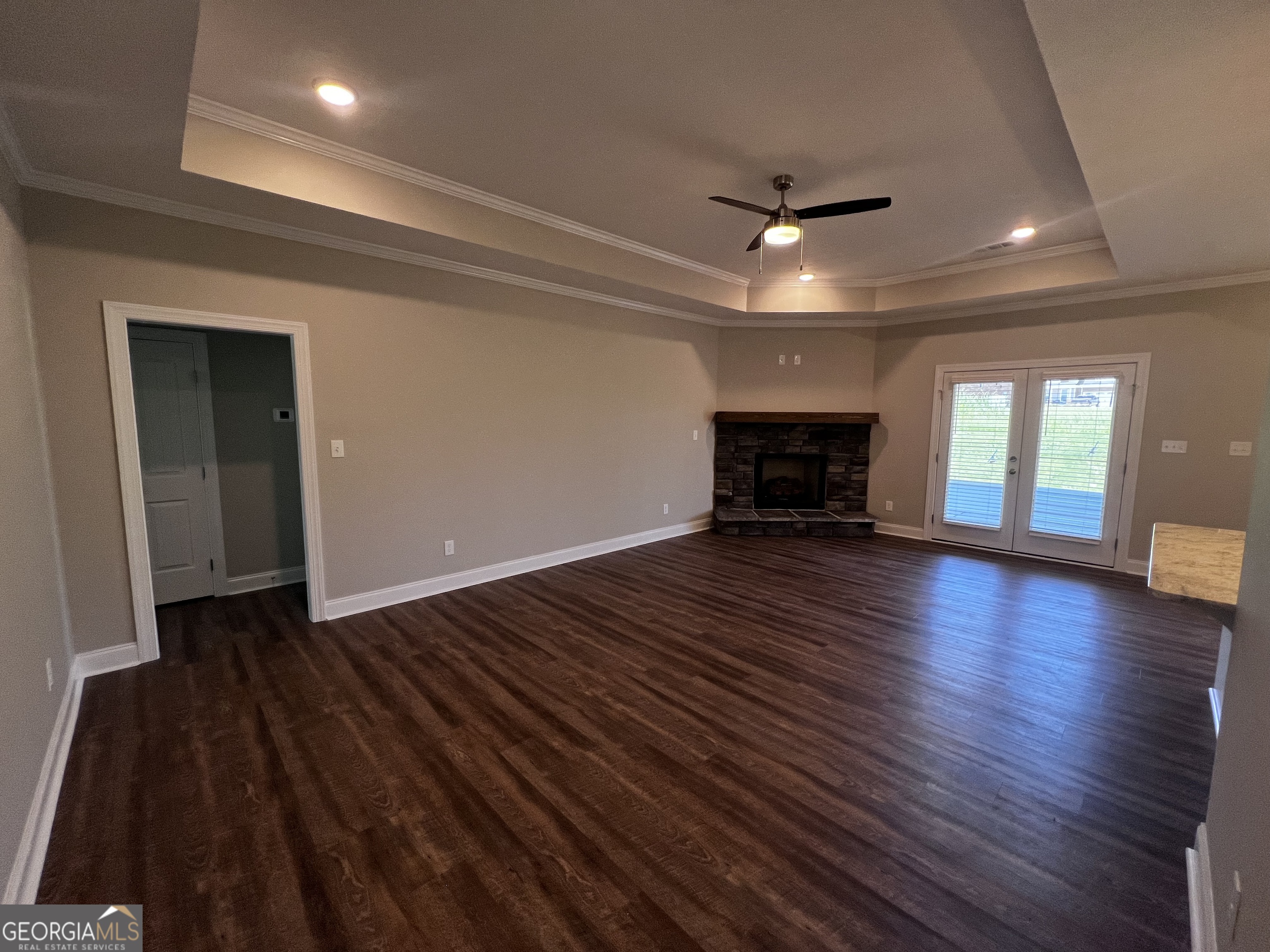 1045 Berkley Court Thomson, GA 30824 - Photo 4 of 32 an empty room with wooden floor fireplace and windows