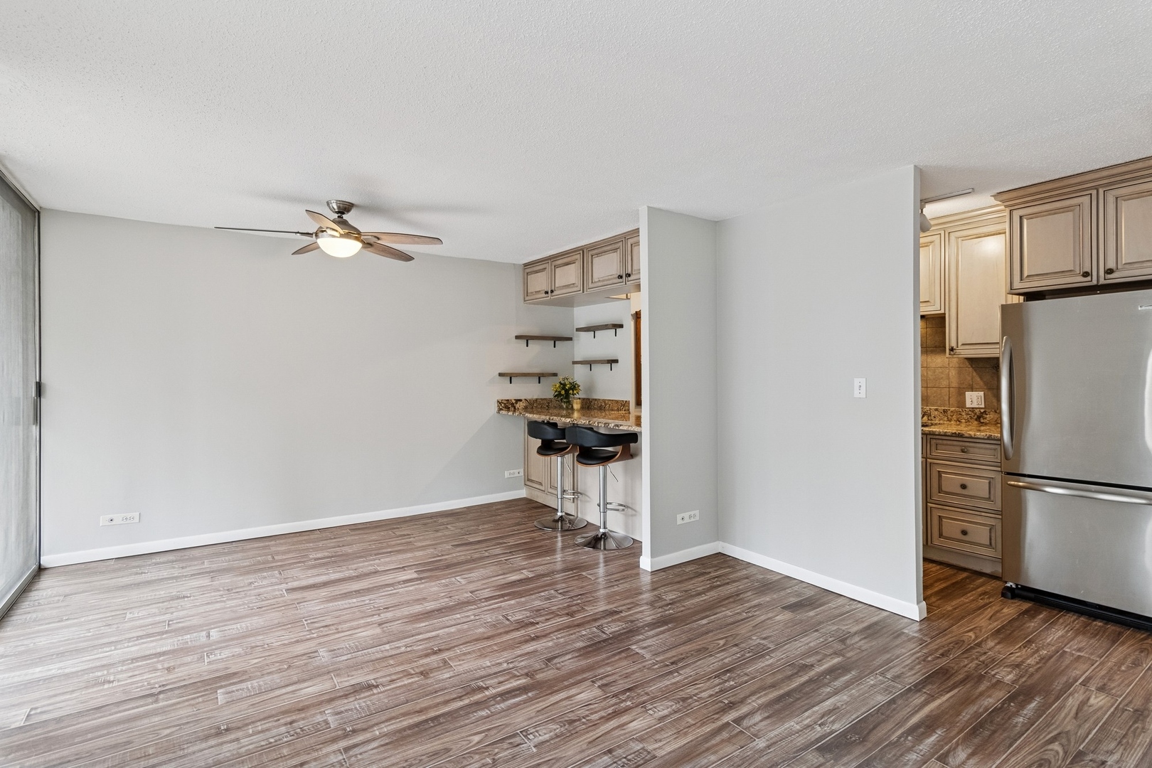 71 East Division Street, Unit 702 Chicago, IL 60611 - Photo 7 of 18 a view of a kitchen with wooden floor and a refrigerator