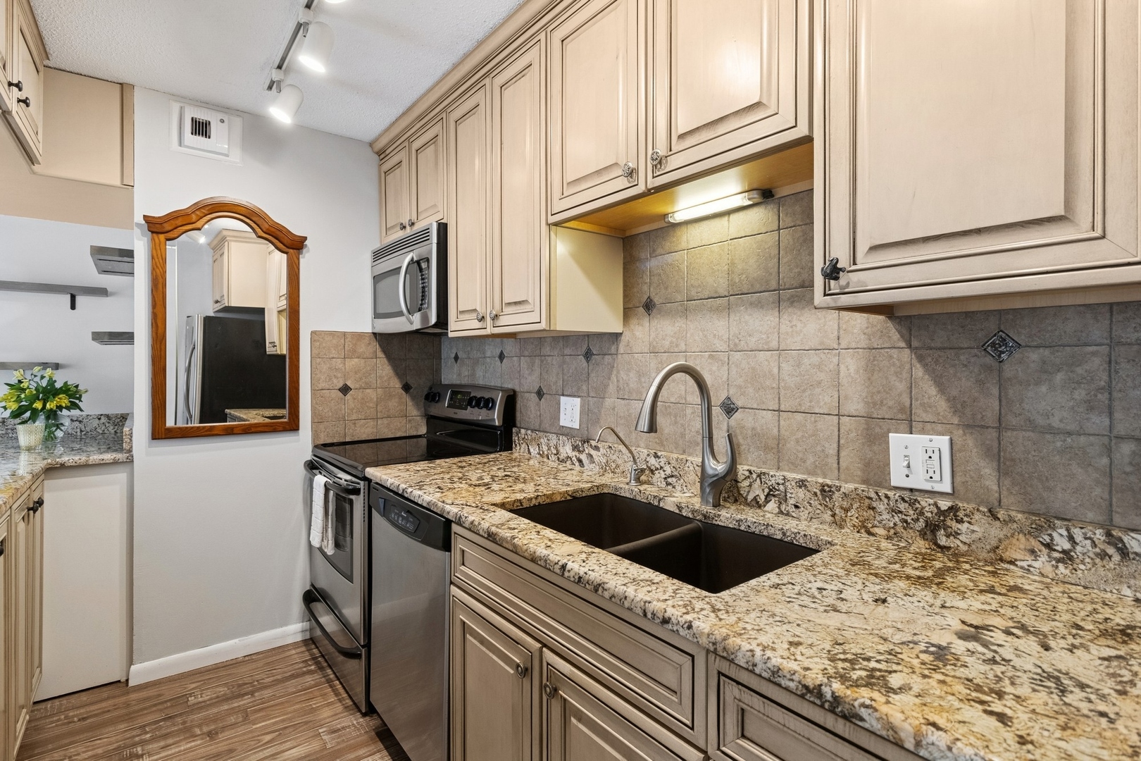 71 East Division Street, Unit 702 Chicago, IL 60611 - Photo 8 of 18 a kitchen with granite countertop a sink a stove and cabinets