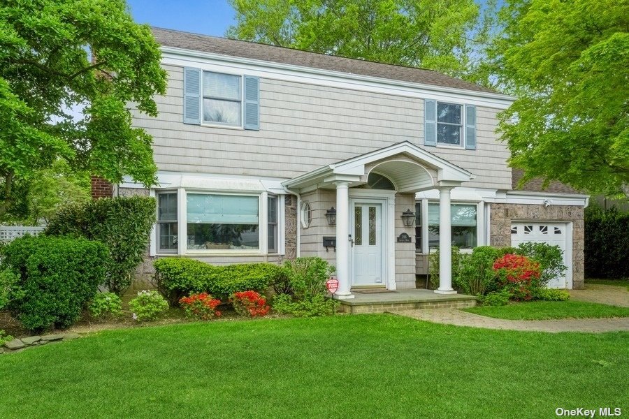 a view of a house with brick walls and a yard with plants