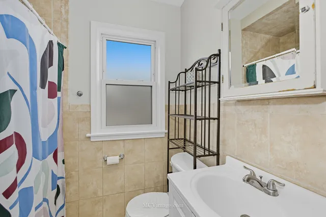 a bathroom with a sink and mirror with bathtub