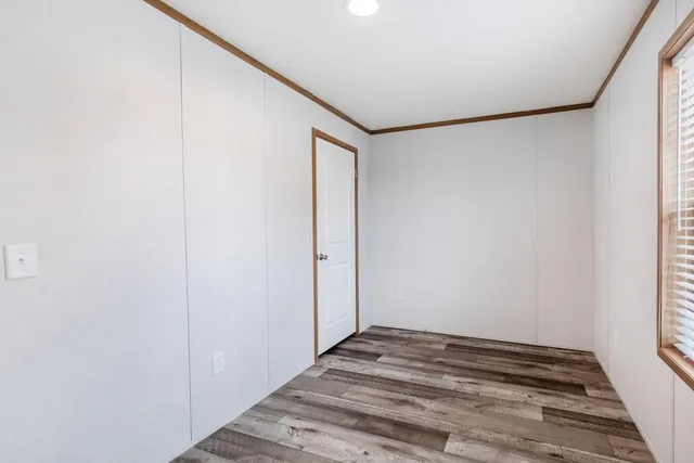 a view of a room with wooden floor and bench