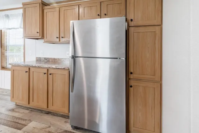 a white refrigerator freezer and a stove sitting inside of a kitchen