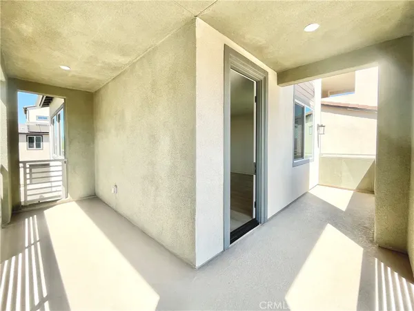 a view of an empty room with wooden floor and entryway