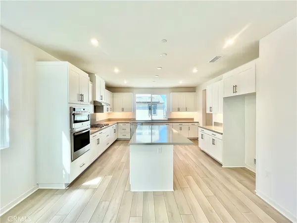 a large kitchen with a lot of counter space and stainless steel appliances