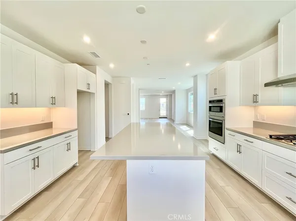 a large kitchen with stainless steel appliances and white cabinets