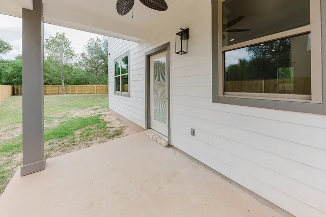 a view of a house with backyard and wooden fence