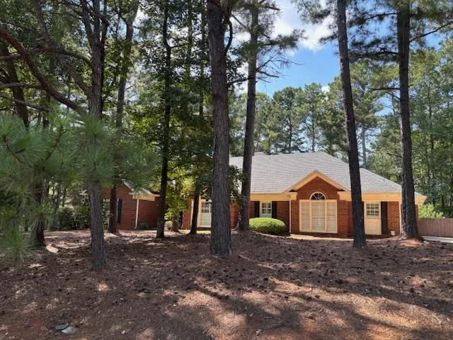 a view of a white house with a yard and tree