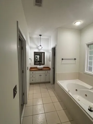 a large white kitchen with a sink stainless steel appliances and cabinets