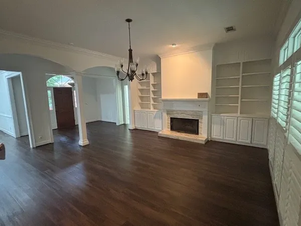 a view of empty room with wooden floor and fireplace