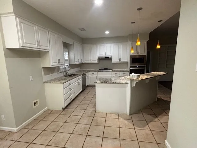 a kitchen with a sink a stove a microwave and cabinets