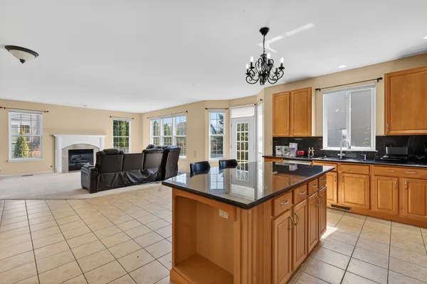a large kitchen with kitchen island granite countertop a sink counter and cabinets