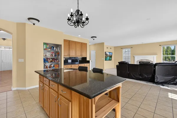 a kitchen with stainless steel appliances granite countertop a sink dishwasher and a refrigerator with wooden floor
