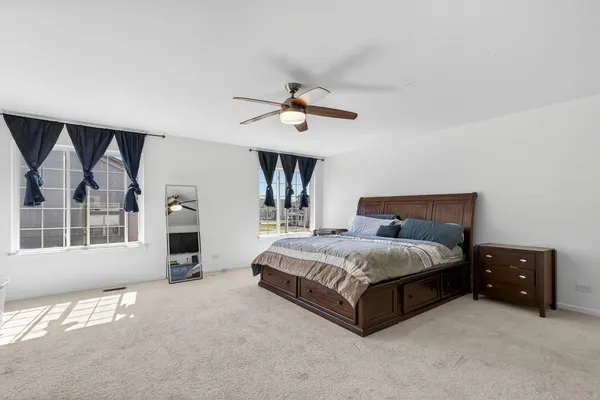 a spacious bedroom with a bed and a chandelier