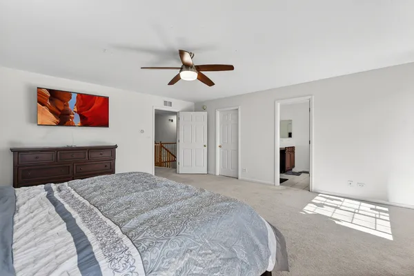 a bedroom with a large bed and a chandelier
