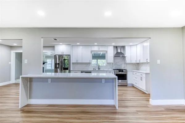 a large kitchen with stainless steel appliances granite countertop a stove and a refrigerator