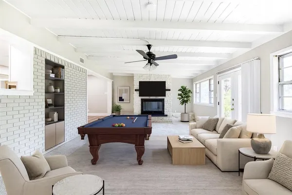 a living room with furniture a fireplace and a chandelier