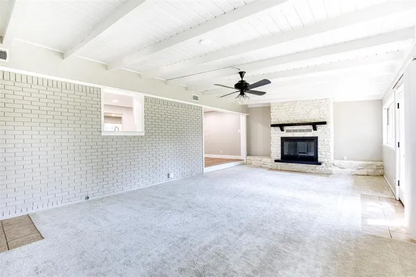 en empty room with windows and fireplace