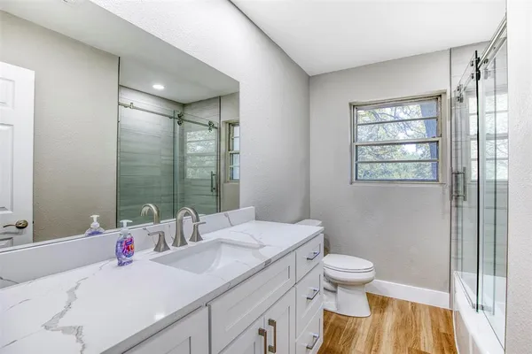 a bathroom with a sink a toilet and shower