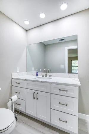 a bathroom with a double vanity sink mirror and toilet