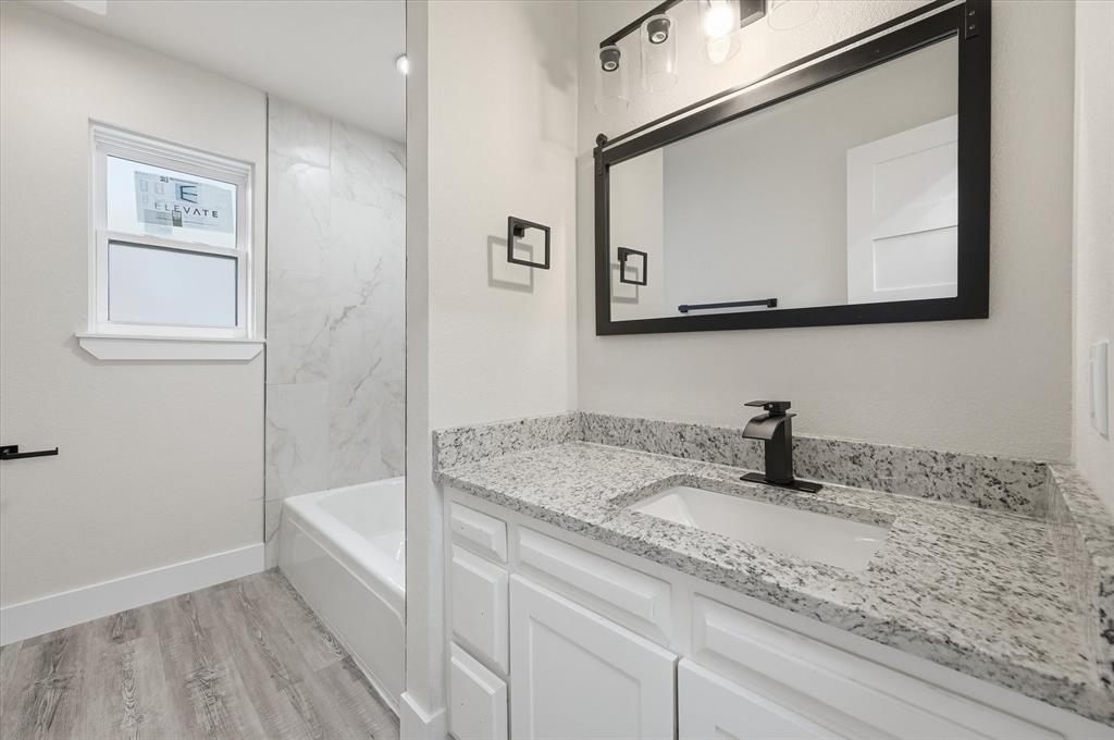 2804 Bent Tree Lane Arlington, TX 76016 - Photo 22 of 32 a bathroom with a granite countertop sink a mirror and vanity